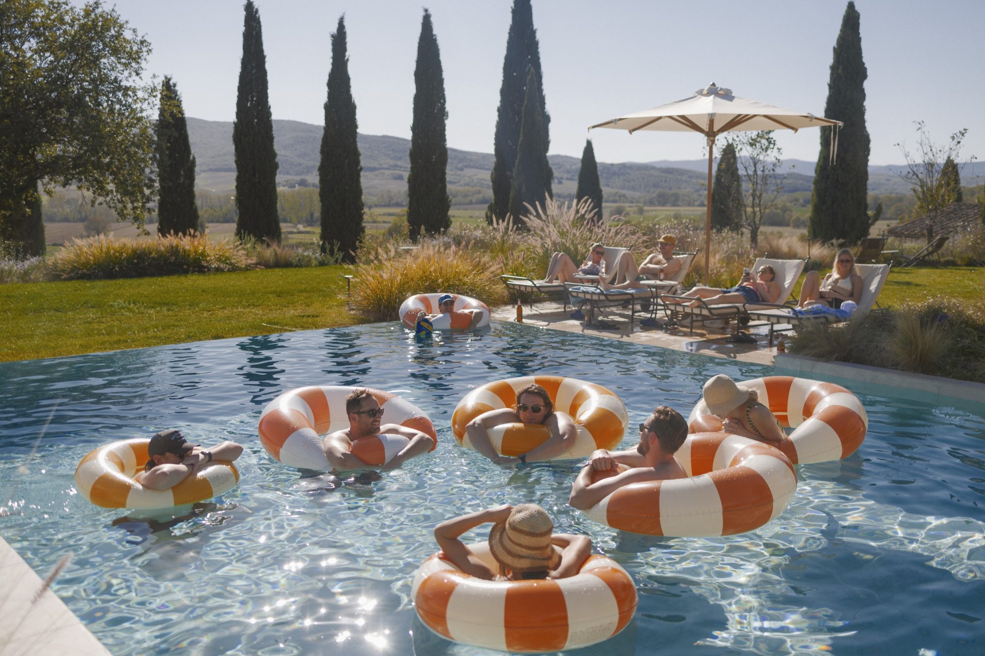 Sun-drenched pool celebration at Ombroneta Villa destination wedding Italy