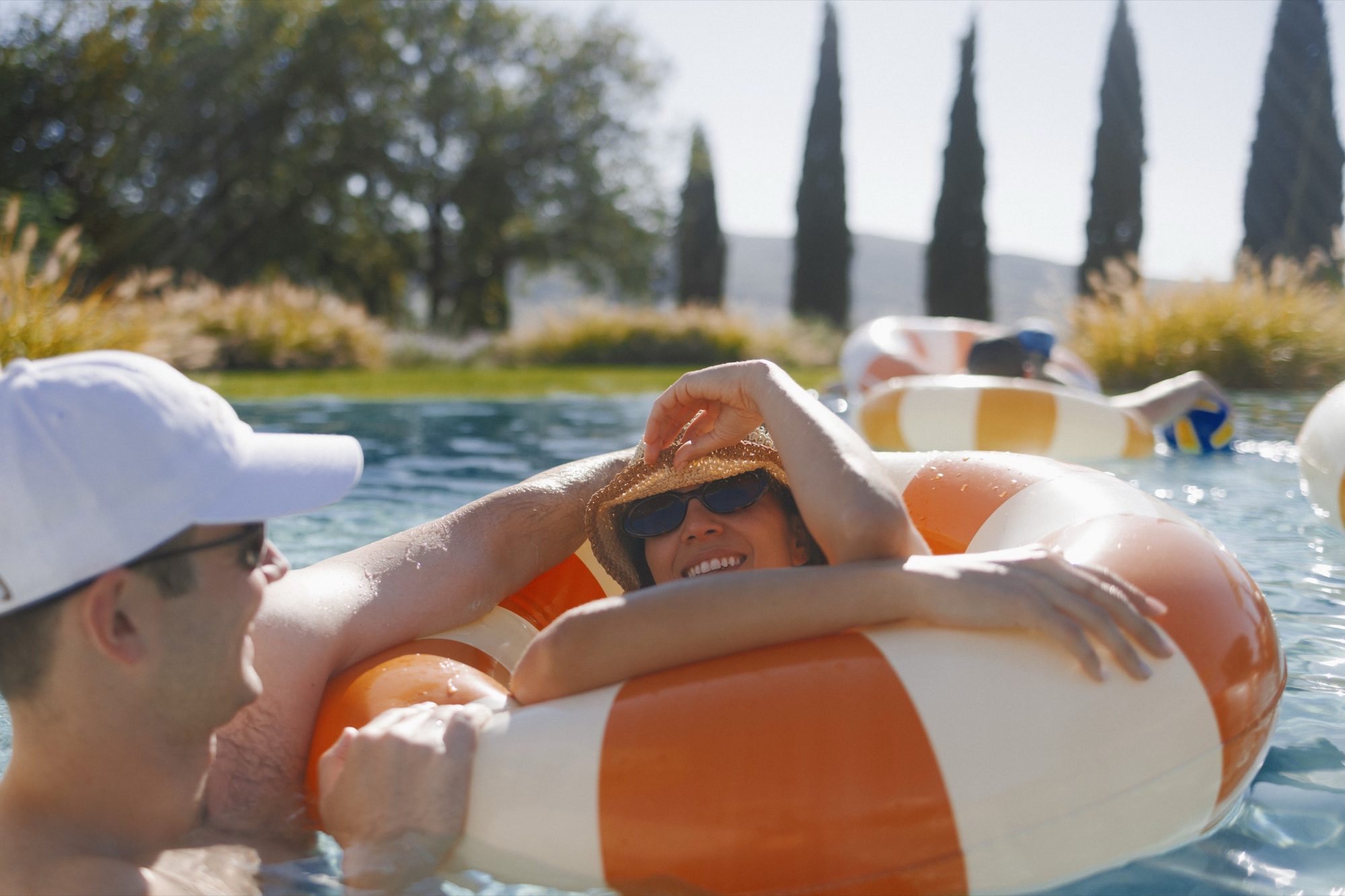 Friends enjoying afternoon aperitivo by the pool at Tuscan villa wedding