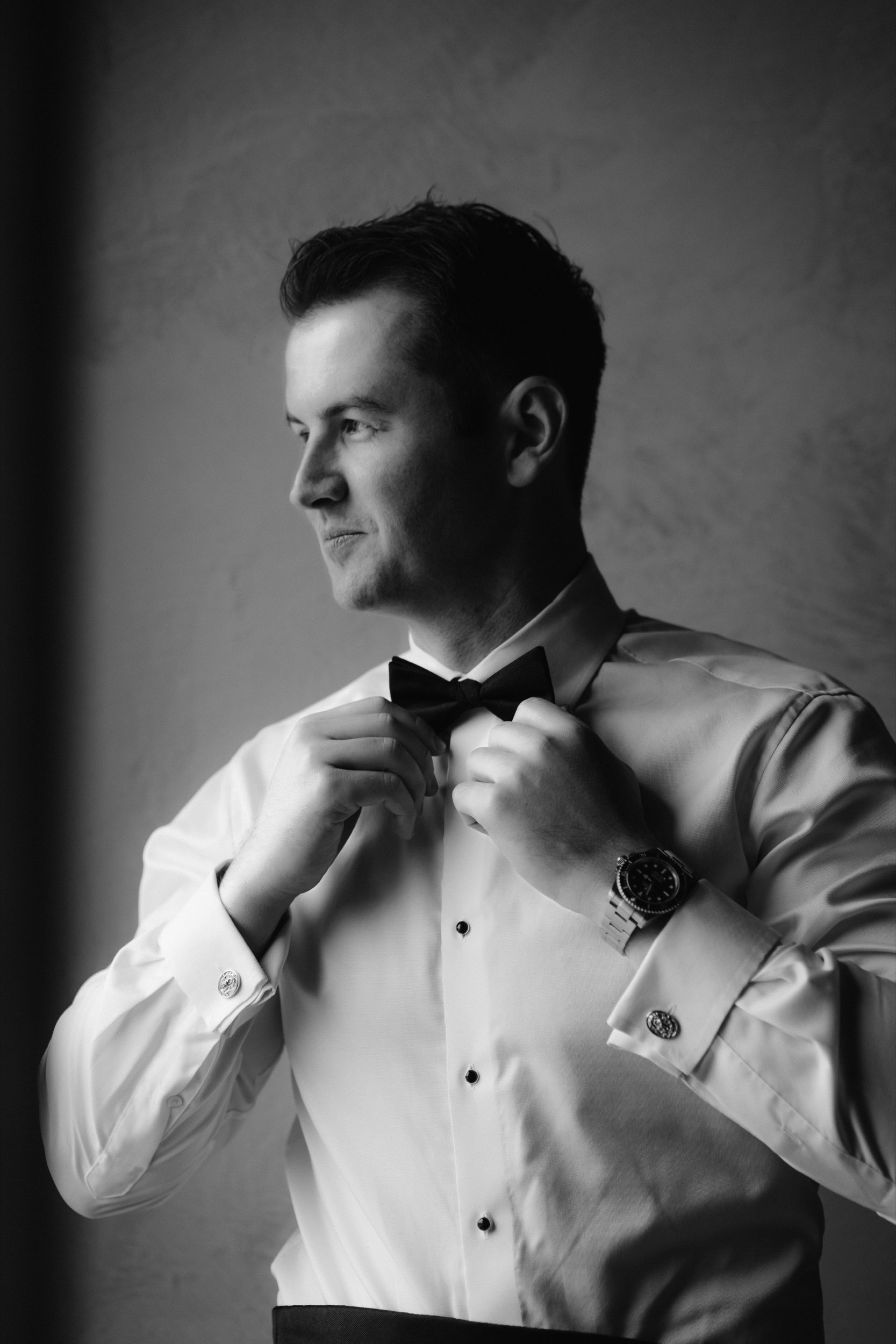 Groom preparation portrait in stone-walled room Ombroneta Villa Tuscany