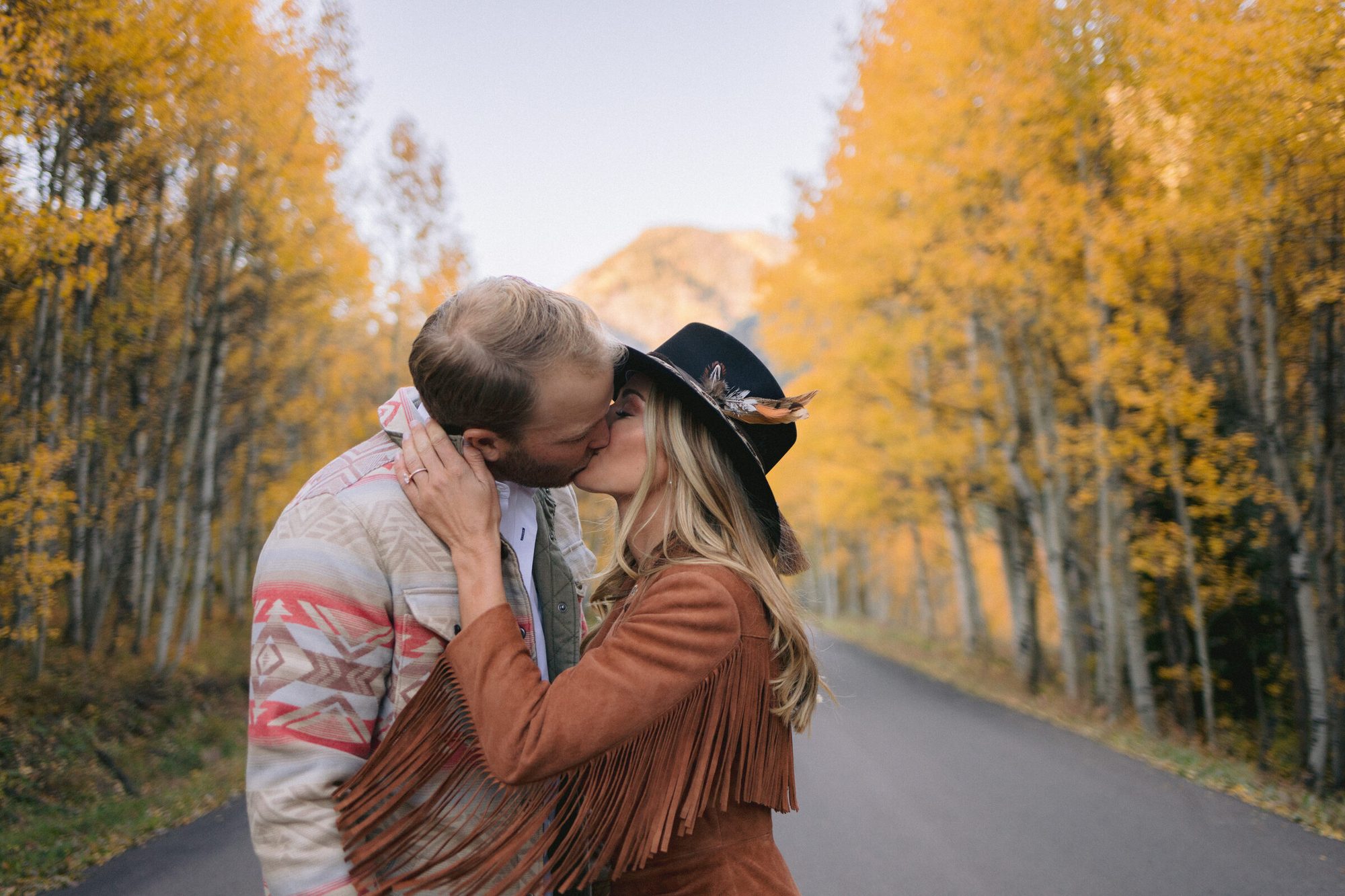 Couple on mountain road at golden hour during Aspen Colorado engagement session