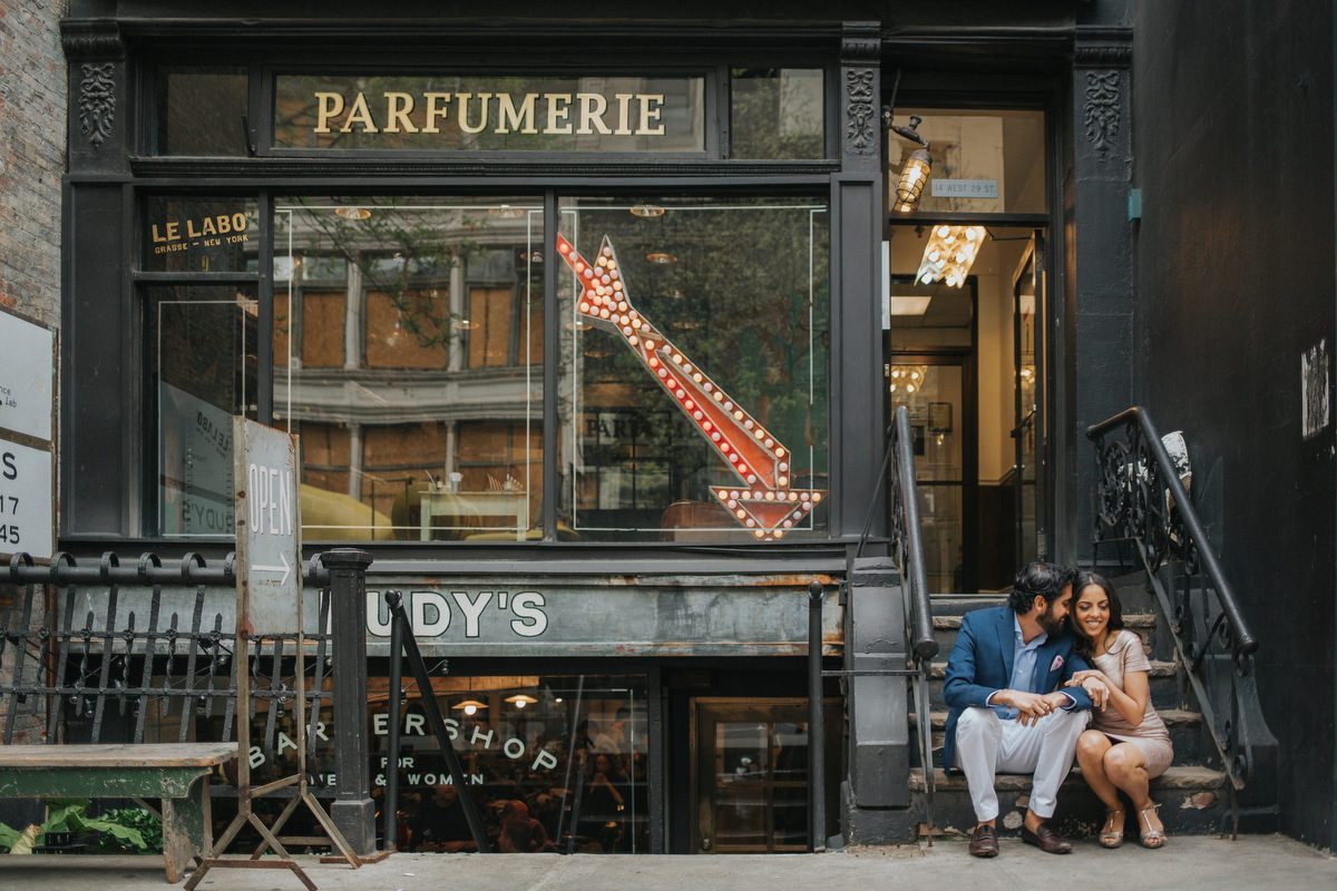 Kavita and Amit sitting together on a classic New York City brownstone stoop during their engagement session by Houston photographer Marco Wang