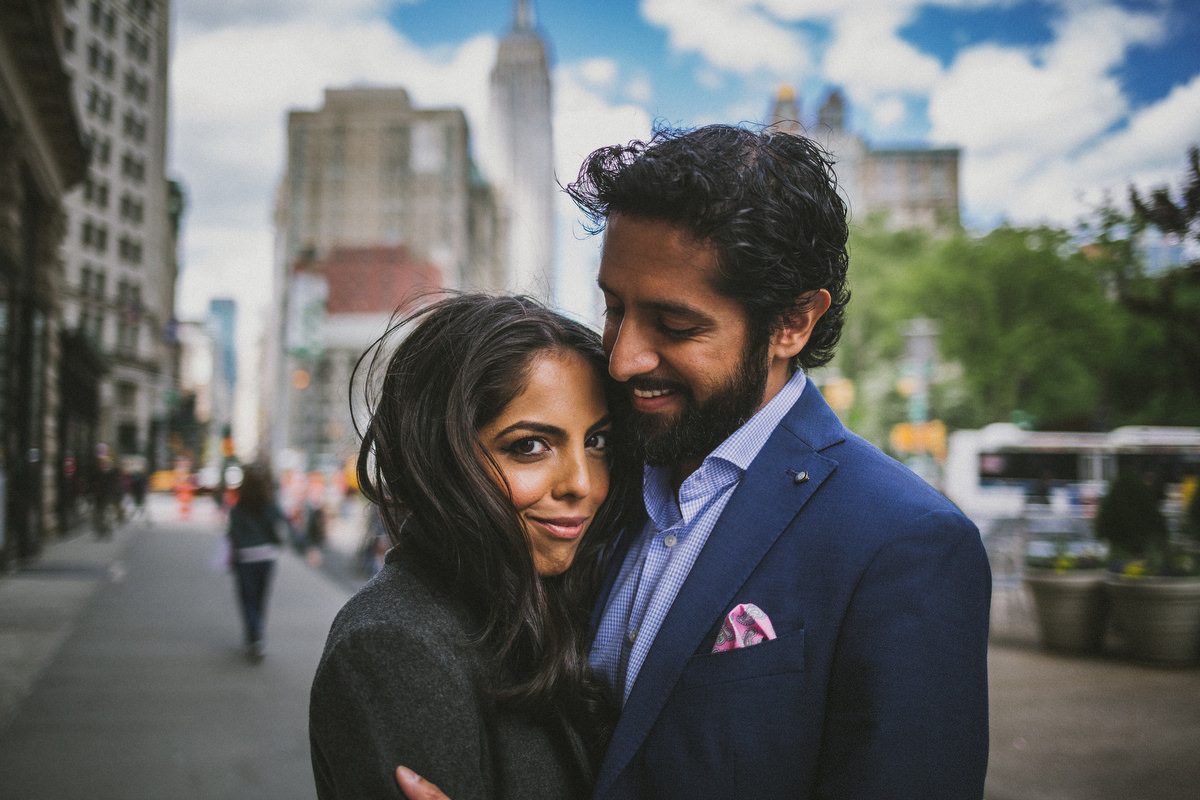 Kavita and Amit embracing in golden city light during their New York City engagement session by Houston photographer Marco Wang