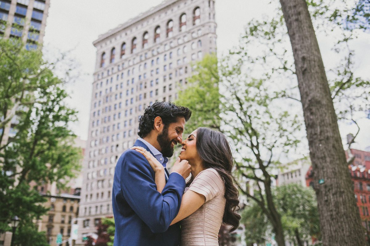 Kavita and Amit posing among Manhattan architecture during their New York City engagement session by Houston photographer Marco Wang