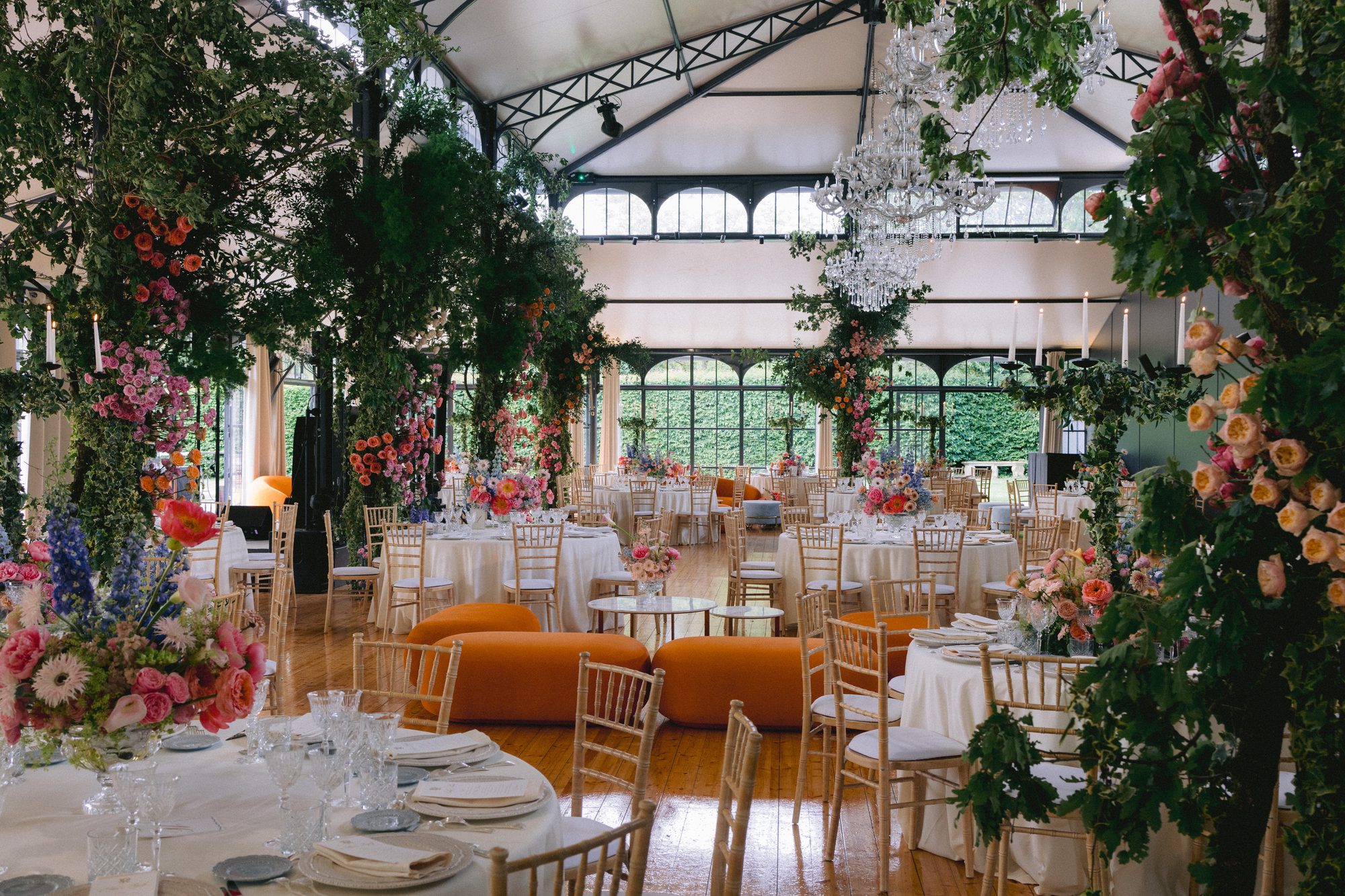 Glass pavilion reception with colorful florals at Chateau de Farcheville France